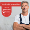 Zufriedener Handwerker mit verschränkten Armen, lächelnd vor einer Baustelle. Rotes Qualitätssiegel von Abdeckfuchs24 mit der Aufschrift „Von Profis empfohlen“ und „Premium Quality